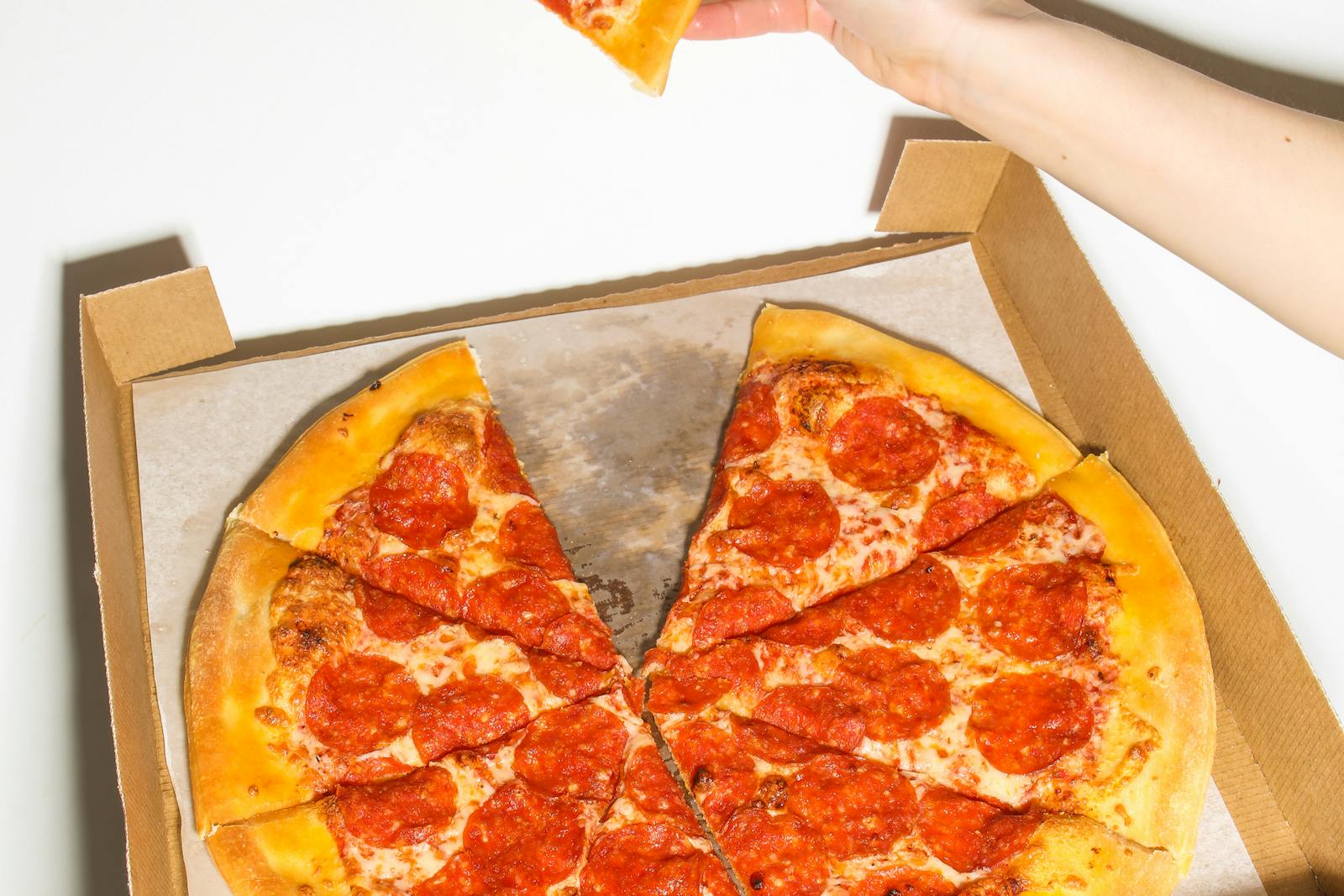 Pepperoni pizza slices in a takeout box